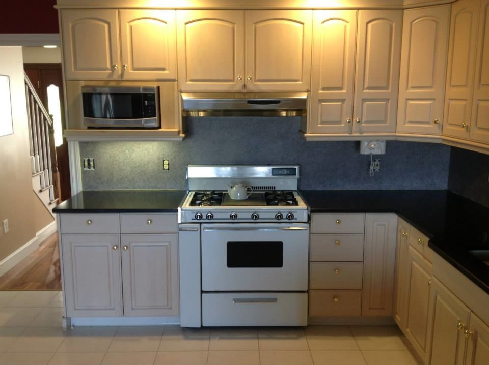 Example of a mid-sized l-shaped ceramic tile open concept kitchen design in Bridgeport with raised-panel cabinets, white cabinets, onyx countertops, multicolored backsplash and white appliances