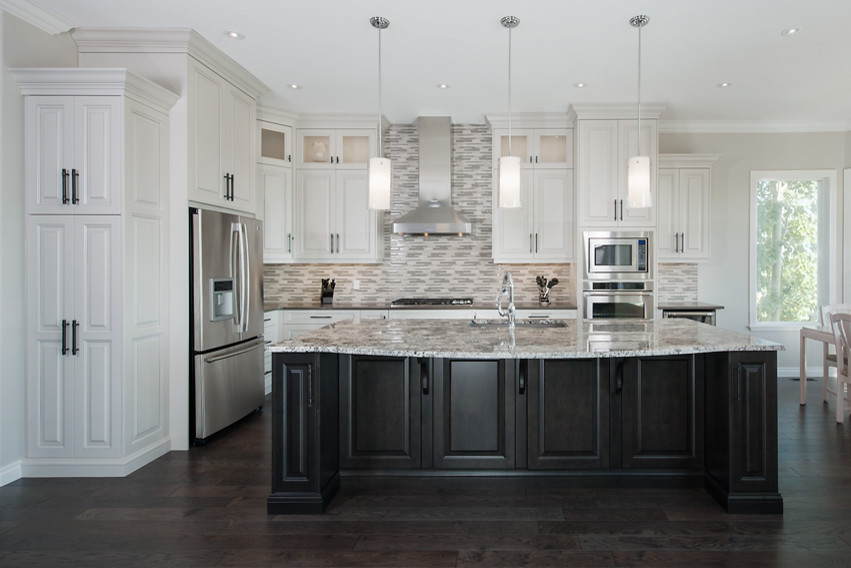 Example of a large transitional l-shaped dark wood floor open concept kitchen design in Calgary with an undermount sink, raised-panel cabinets, white cabinets, granite countertops, multicolored backsplash, matchstick tile backsplash, stainless steel appliances and an island