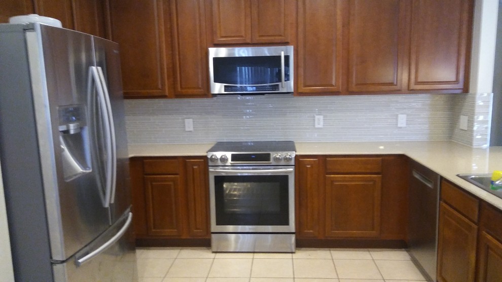Inspiration for a mid-sized transitional l-shaped eat-in kitchen remodel with quartz countertops, white backsplash, glass tile backsplash and a peninsula