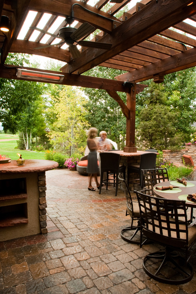 Photo of a large traditional backyard patio in Denver with concrete pavers.