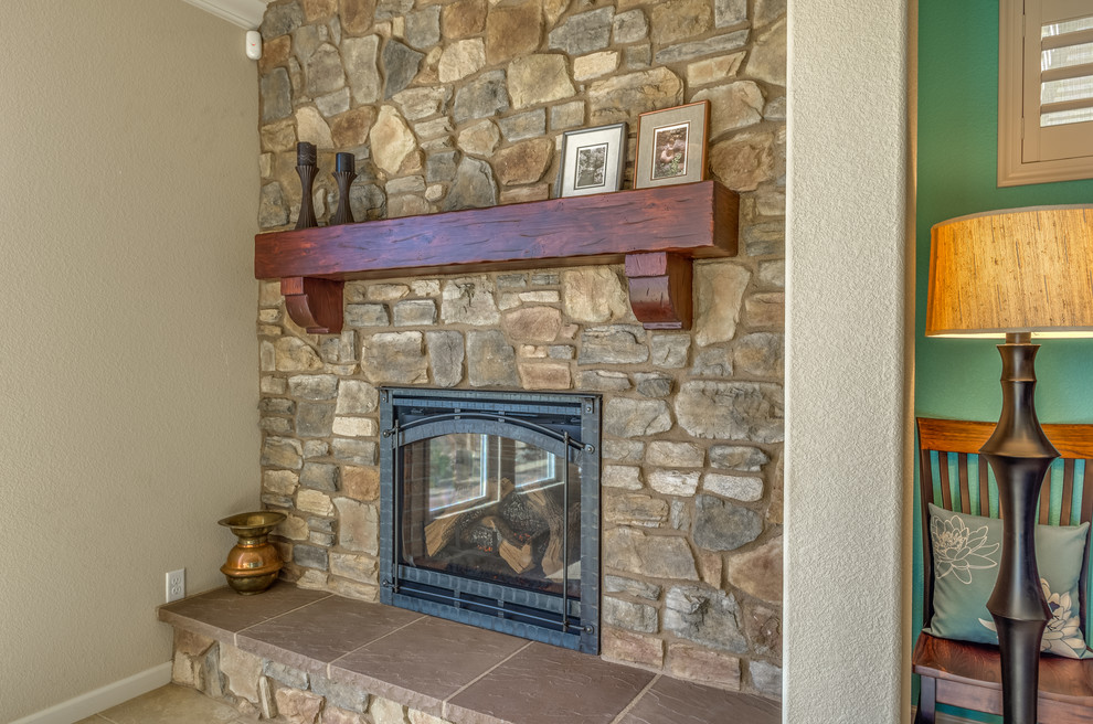 Photo of a small country open concept living room in Other with a stone fireplace surround.