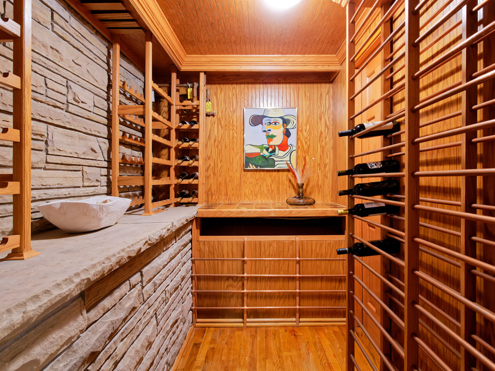 Photo of a modern wine cellar in Denver with light hardwood floors.