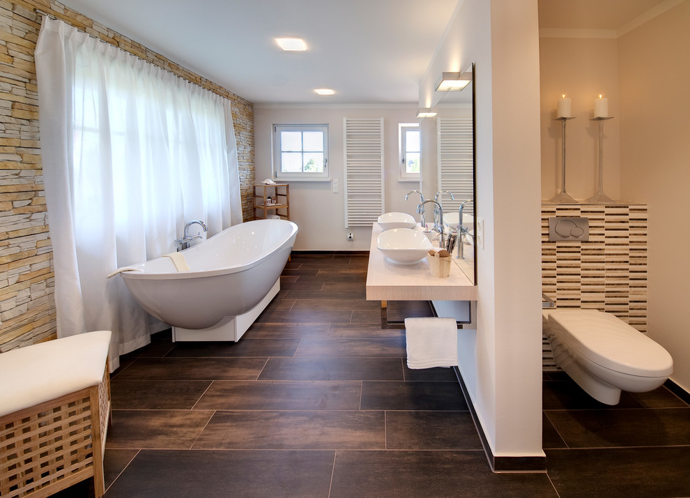 Design ideas for a large mediterranean master bathroom in Munich with open cabinets, brown cabinets, a freestanding tub, an open shower, a one-piece toilet, brown tile, porcelain tile, brown walls, porcelain floors, a vessel sink, wood benchtops, brown floor, an open shower and beige benchtops.