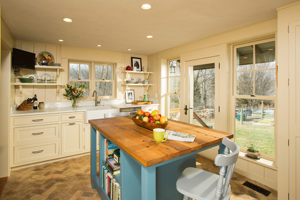 Mid-sized country kitchen in DC Metro with a farmhouse sink, recessed-panel cabinets, white cabinets, marble benchtops, stainless steel appliances, brick floors and with island.