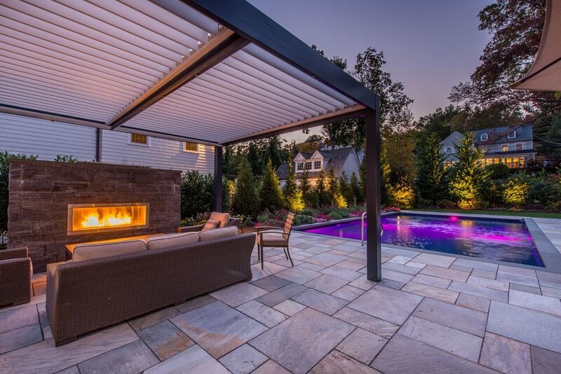 This is an example of a large transitional backyard patio in New York with a fire feature, natural stone pavers and a gazebo/cabana.