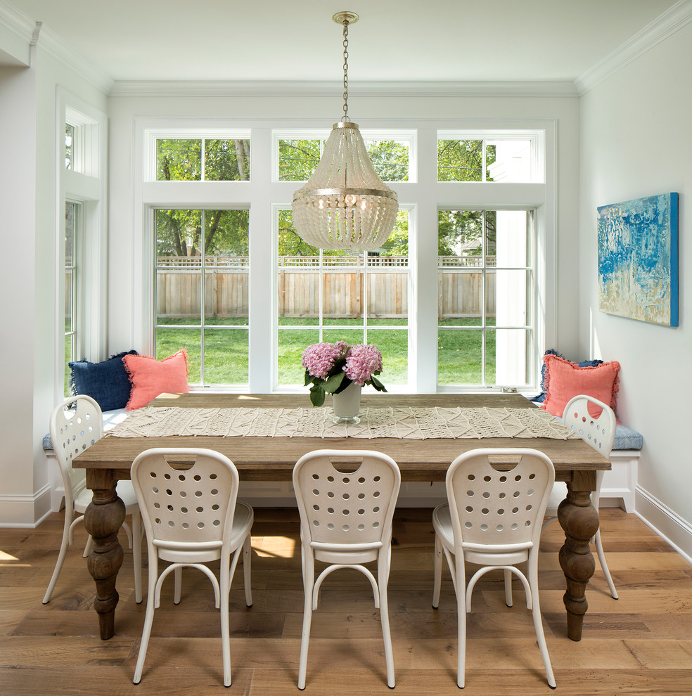 Design ideas for a small transitional open plan dining in Minneapolis with light hardwood floors and white walls.