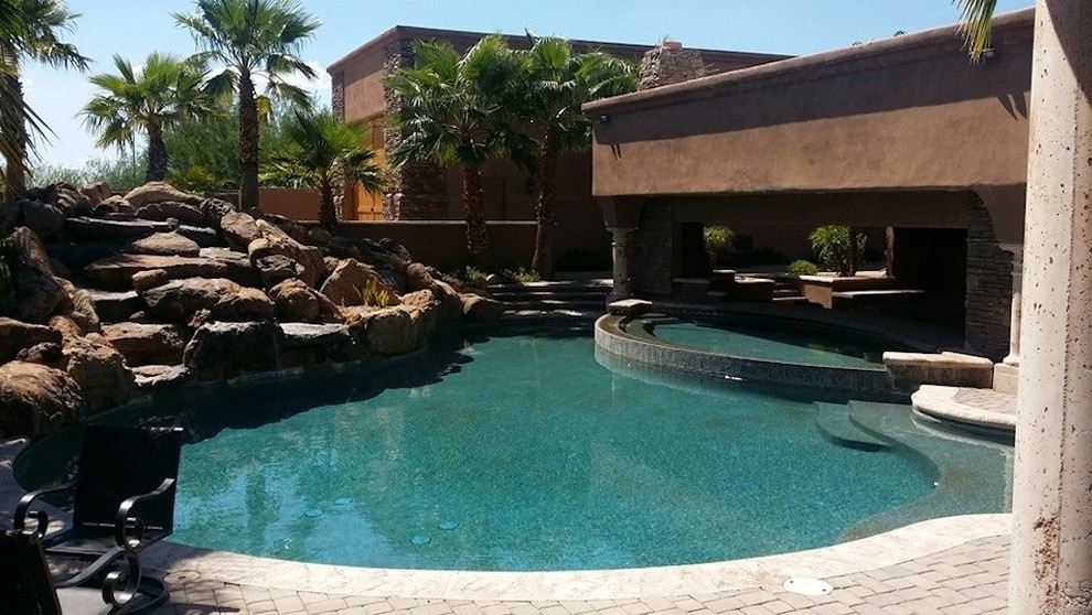 Inspiration for a large rustic backyard rectangular lap pool fountain remodel in Phoenix