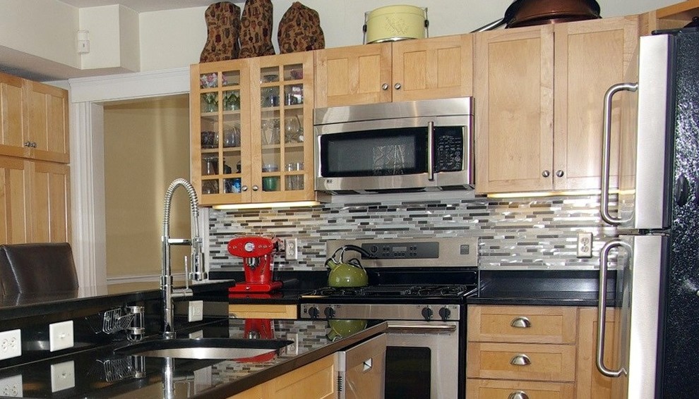 This is an example of a contemporary eat-in kitchen in Miami with metal splashback.
