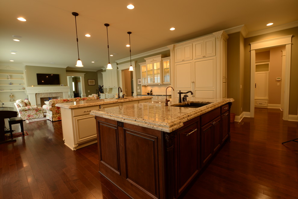 Expansive traditional kitchen in Indianapolis with raised-panel cabinets, white cabinets, granite benchtops, stone tile splashback and multiple islands.