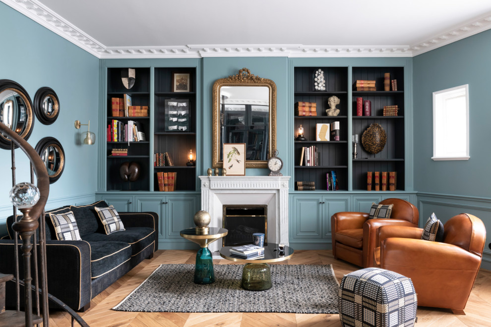 Mid-sized transitional enclosed living room in Angers with a library, blue walls, light hardwood floors, a standard fireplace, no tv, beige floor, coffered and panelled walls.