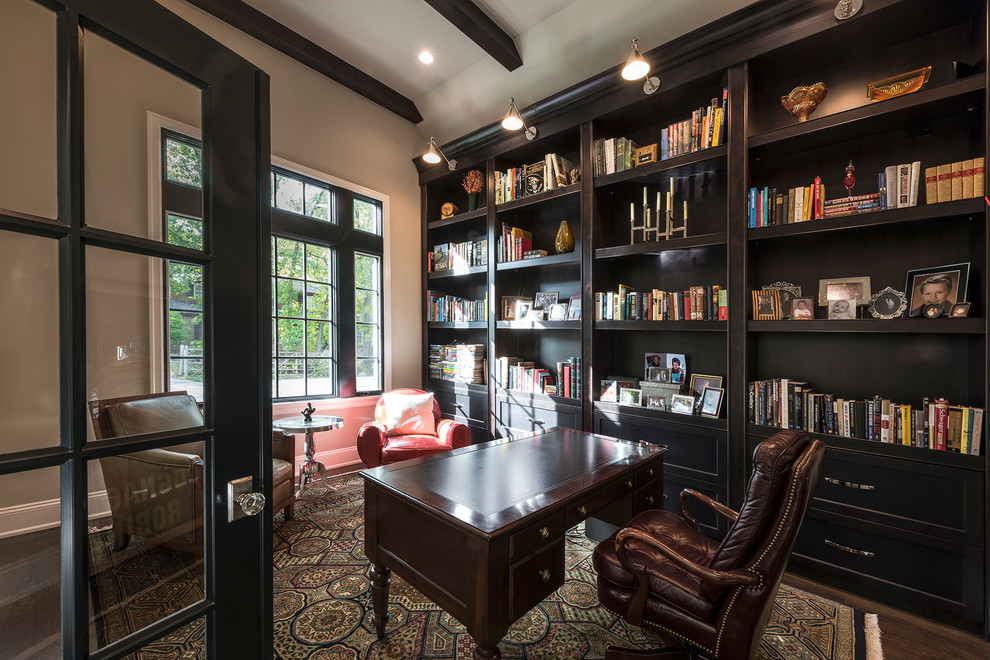 Inspiration for a mid-sized traditional home office in Chicago with a library, beige walls, dark hardwood floors, a built-in desk and brown floor.