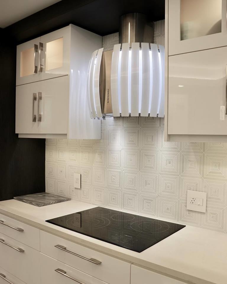Photo of a small contemporary single-wall open plan kitchen in Miami with an undermount sink, flat-panel cabinets, white cabinets, marble benchtops, white splashback, white appliances, porcelain floors, with island, beige floor and grey benchtop.