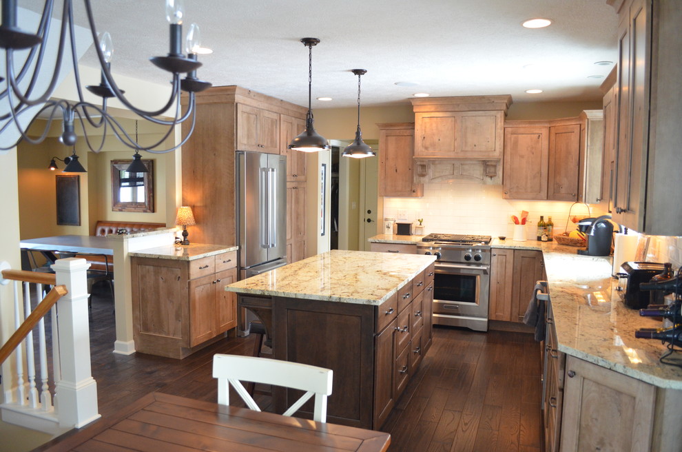 Mountain style l-shaped dark wood floor eat-in kitchen photo with an undermount sink, shaker cabinets, medium tone wood cabinets, laminate countertops, black backsplash, subway tile backsplash, stainless steel appliances and two islands
