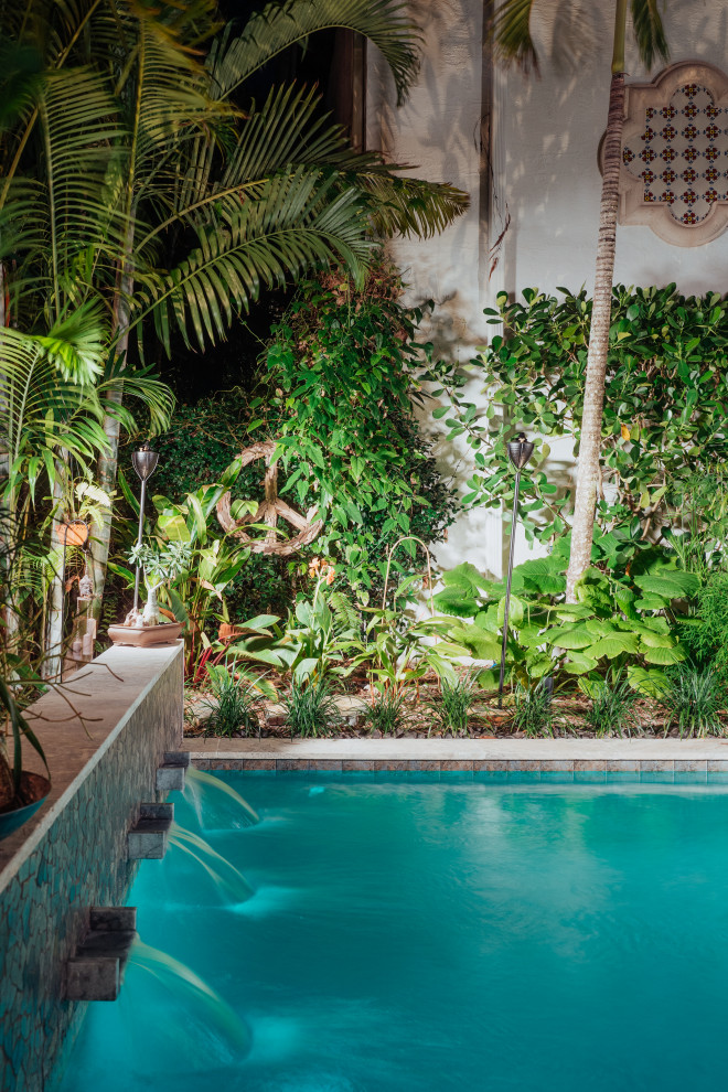 Ispirazione per una piccola piscina monocorsia etnica rettangolare dietro casa con paesaggistica bordo piscina e pavimentazioni in pietra naturale