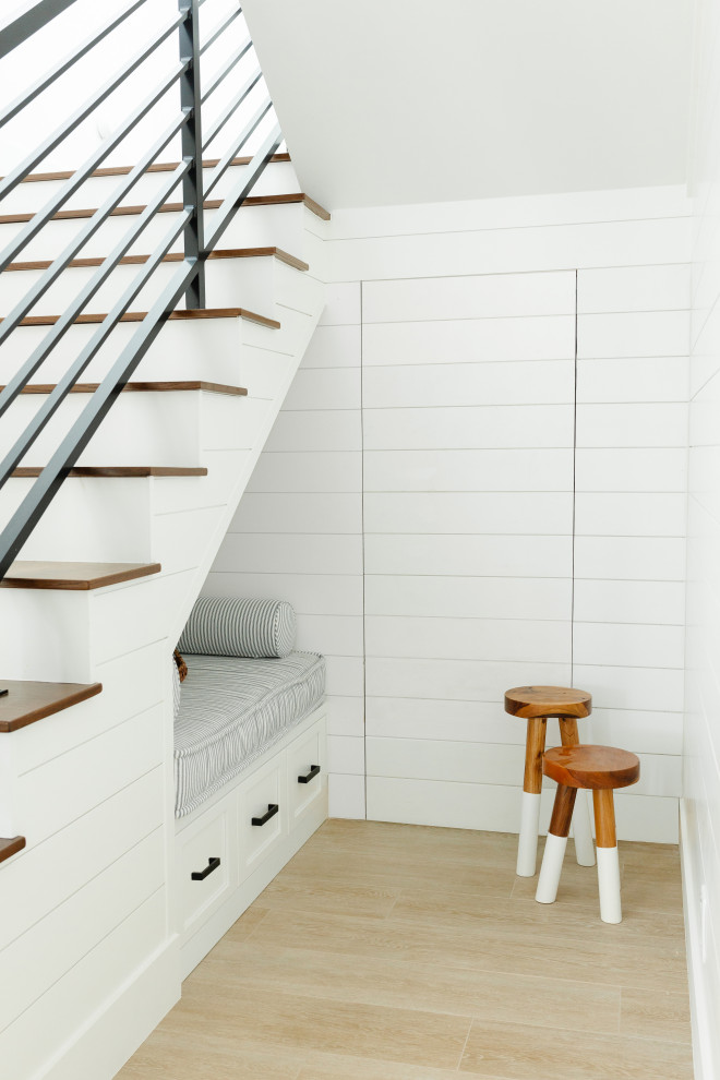 Imagen de escalera marinera grande con escalones de madera, contrahuellas de madera pintada, barandilla de metal y machihembrado
