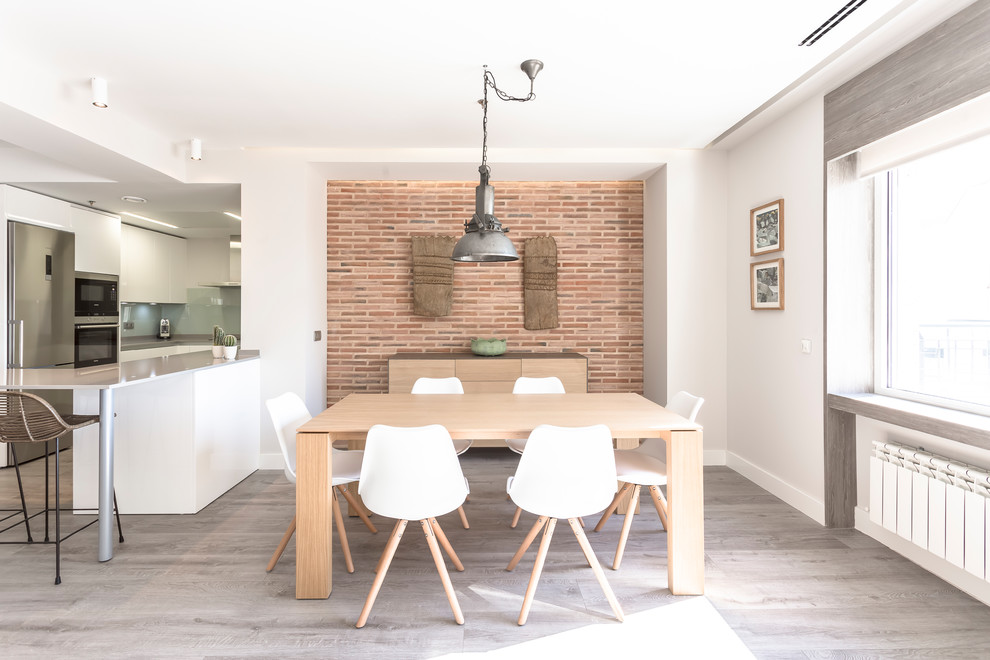 Modelo de comedor de cocina actual de tamaño medio sin chimenea con paredes blancas, suelo marrón y suelo de madera en tonos medios