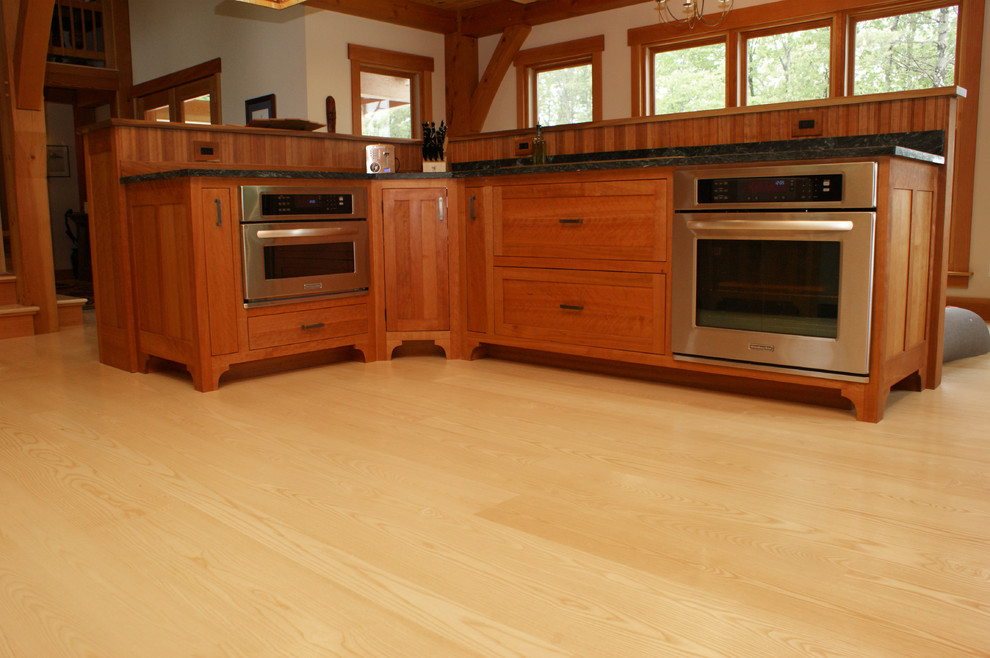 This is an example of an arts and crafts kitchen in Boston with light hardwood floors.