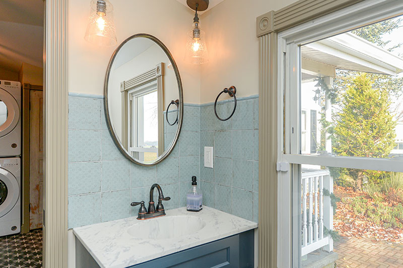 Idée de décoration pour une salle de bain champêtre de taille moyenne avec des portes de placard bleues, WC à poser, un mur beige, un lavabo intégré, une cabine de douche à porte coulissante, buanderie, meuble simple vasque et meuble-lavabo encastré.