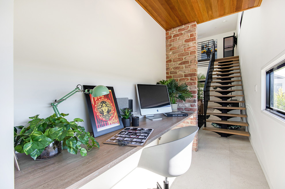 Inspiration for an industrial study room in Sunshine Coast with white walls, ceramic floors, a built-in desk and beige floor.