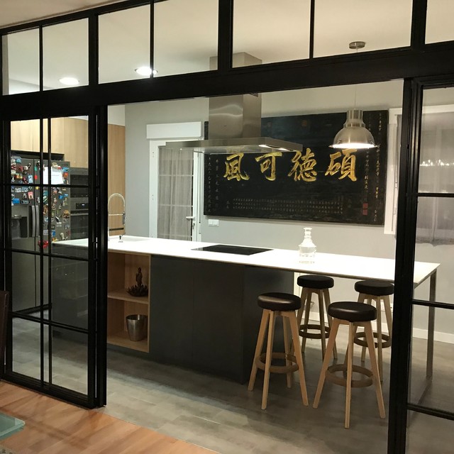 Una cocina con isla y puertas correderas de cristal con acento oriental
