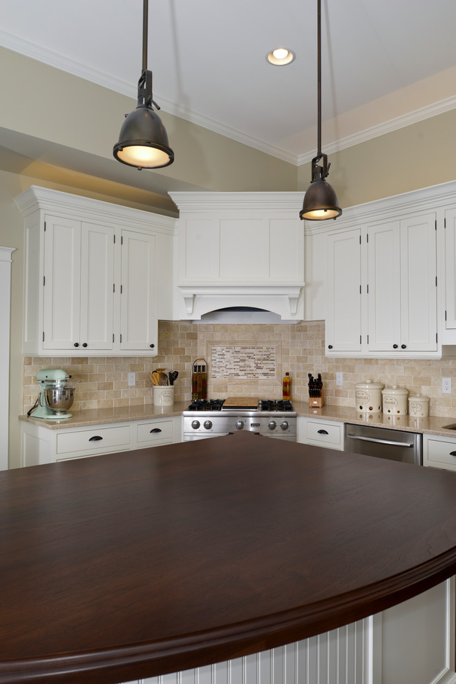 Transitional l-shaped open plan kitchen in Chicago with an undermount sink, beaded inset cabinets, white cabinets, wood benchtops, beige splashback, stone tile splashback, stainless steel appliances, dark hardwood floors and with island.