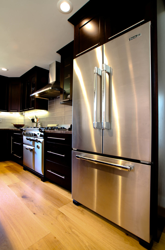 Photo of a contemporary l-shaped eat-in kitchen in San Francisco with an undermount sink, flat-panel cabinets, stainless steel cabinets, soapstone benchtops, grey splashback, matchstick tile splashback and stainless steel appliances.