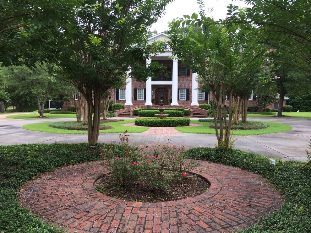 Expansive traditional front yard partial sun driveway in Jackson with a water feature and brick pavers for summer.