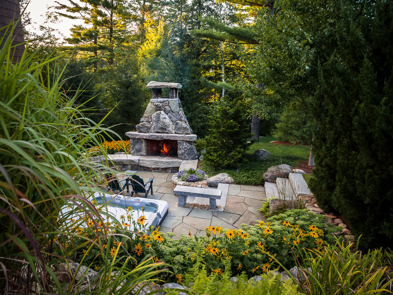 Mid-sized country backyard patio in Portland Maine with a fire feature and no cover.