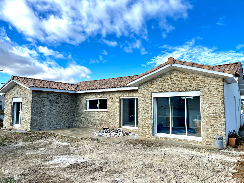 Large and beige mediterranean bungalow detached house in Montpellier with stone cladding.