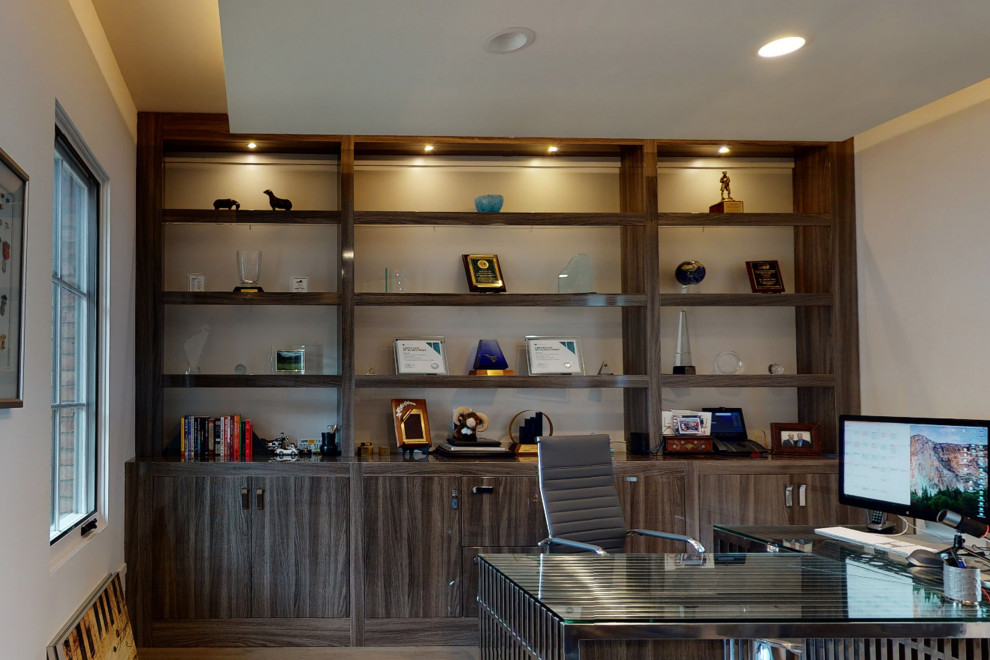 Example of a large minimalist freestanding desk medium tone wood floor, brown floor and tray ceiling home office design in Orange County with beige walls