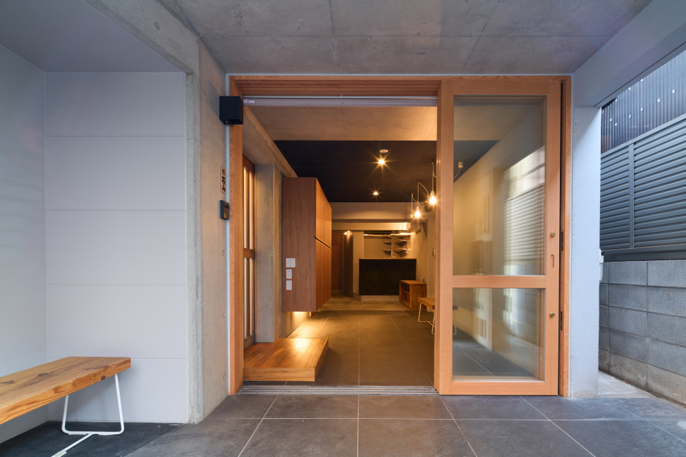 Источник вдохновения для домашнего уюта: фойе среднего размера в стиле модернизм с серыми стенами, полом из керамической плитки, раздвижной входной дверью и черным полом
