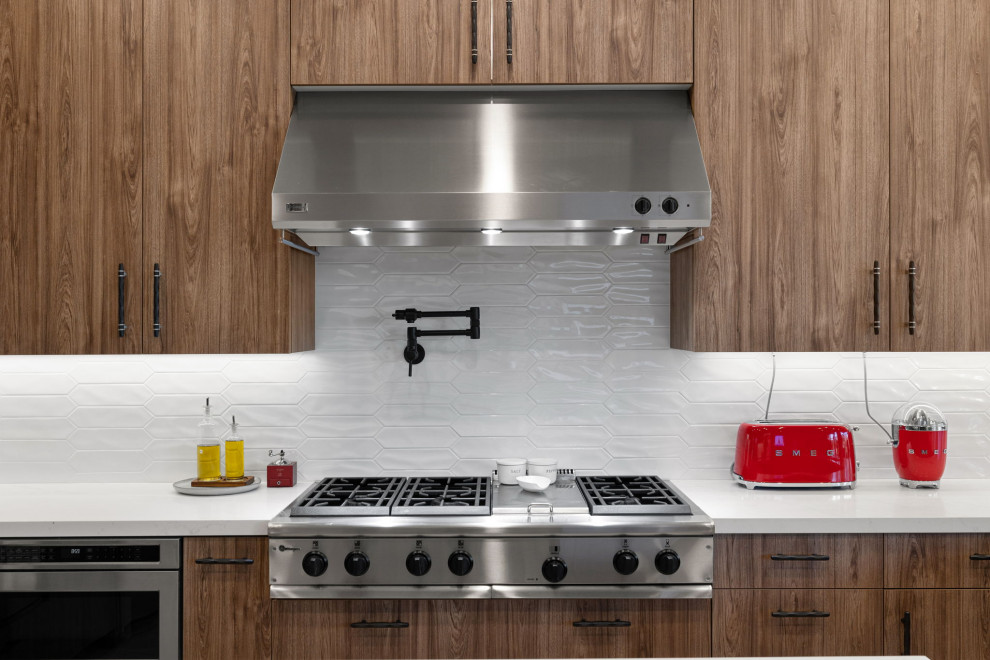 Mountain style l-shaped slate floor and beige floor enclosed kitchen photo with a single-bowl sink, flat-panel cabinets, medium tone wood cabinets, quartzite countertops, white backsplash, glass sheet backsplash, stainless steel appliances, a peninsula and white countertops