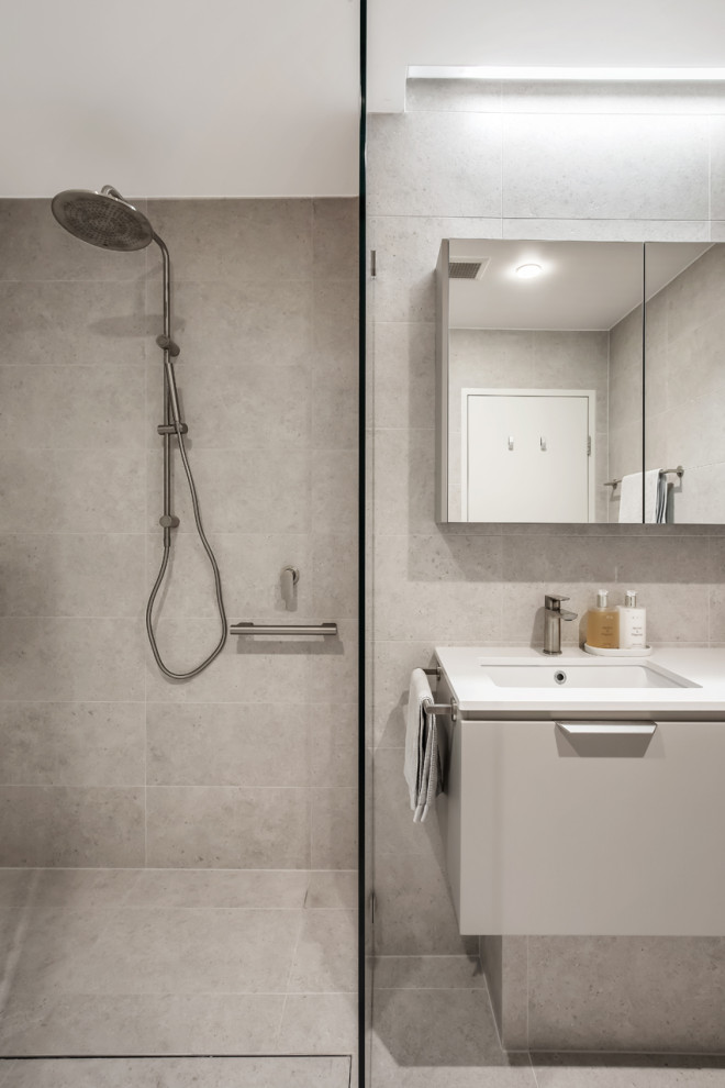 Mid-sized contemporary 3/4 bathroom in Sydney with flat-panel cabinets, grey cabinets, a freestanding tub, a corner shower, a one-piece toilet, gray tile, porcelain tile, grey walls, porcelain floors, a vessel sink, engineered quartz benchtops, grey floor, a hinged shower door, white benchtops, a double vanity and a floating vanity.
