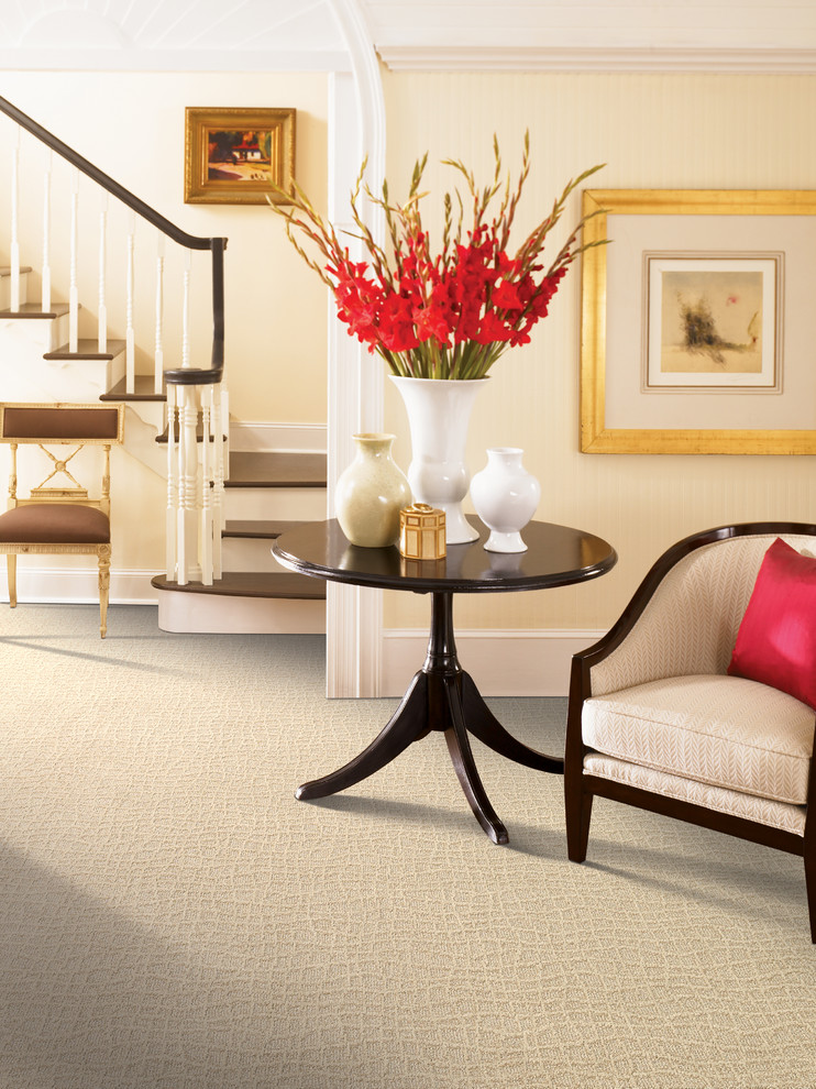 Design ideas for a mid-sized traditional foyer in Charlotte with beige walls, carpet and beige floor.