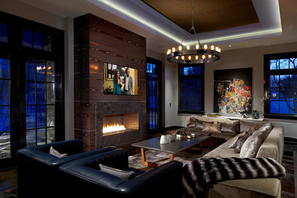 Large contemporary open concept family room in New York with grey walls, dark hardwood floors, a ribbon fireplace, a wall-mounted tv and a stone fireplace surround.