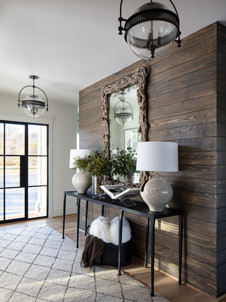 This is an example of a mid-sized country foyer in Richmond with white walls, medium hardwood floors, a single front door, a glass front door, beige floor and planked wall panelling.