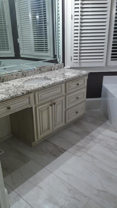 Inspiration for a mid-sized traditional master bathroom in Atlanta with raised-panel cabinets, white cabinets, a drop-in tub, a corner shower, an urinal, brown tile, porcelain tile, purple walls, porcelain floors, a drop-in sink and granite benchtops.