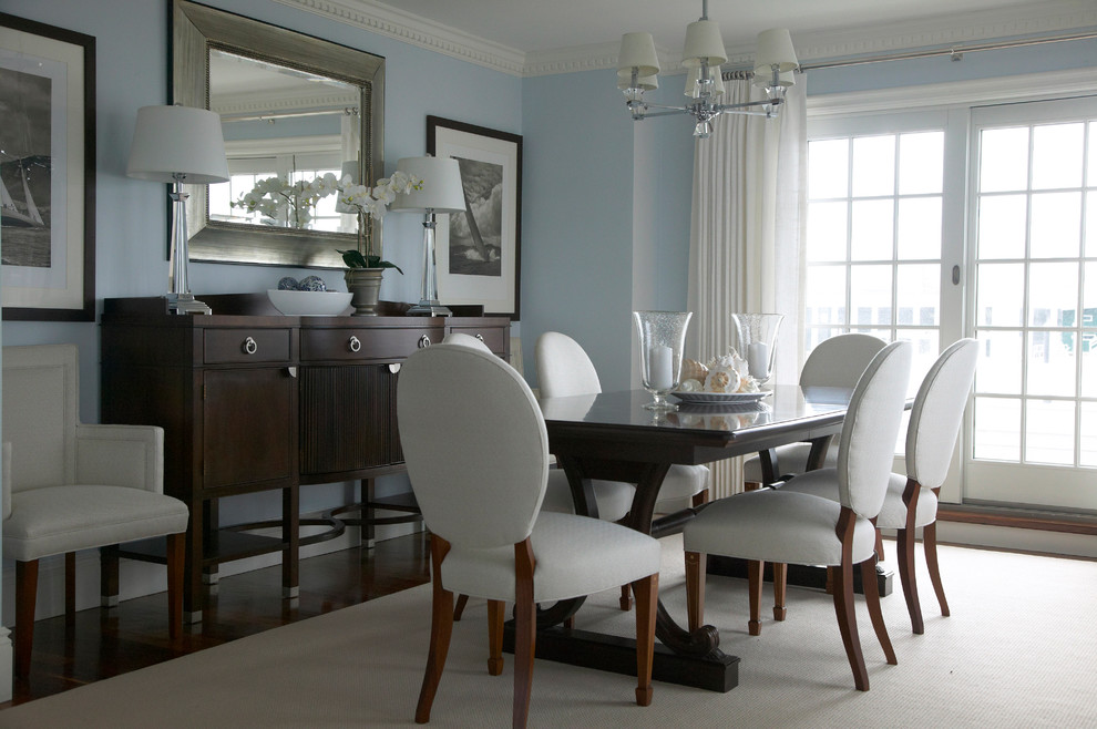 Photo of a beach style dining room in New York with blue walls and dark hardwood floors.