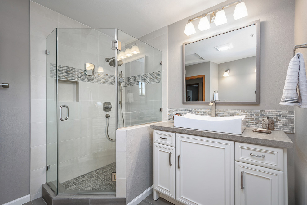This is an example of a mid-sized contemporary 3/4 bathroom in San Francisco with recessed-panel cabinets, a corner shower, a two-piece toilet, gray tile, porcelain tile, grey walls, porcelain floors, a vessel sink, concrete benchtops, grey floor and a hinged shower door.