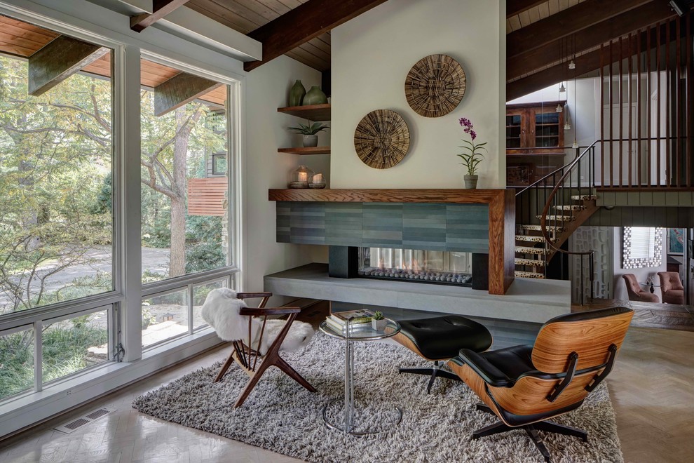 Photo of a midcentury formal open concept living room in Chicago with white walls, light hardwood floors, a ribbon fireplace, a metal fireplace surround and beige floor.