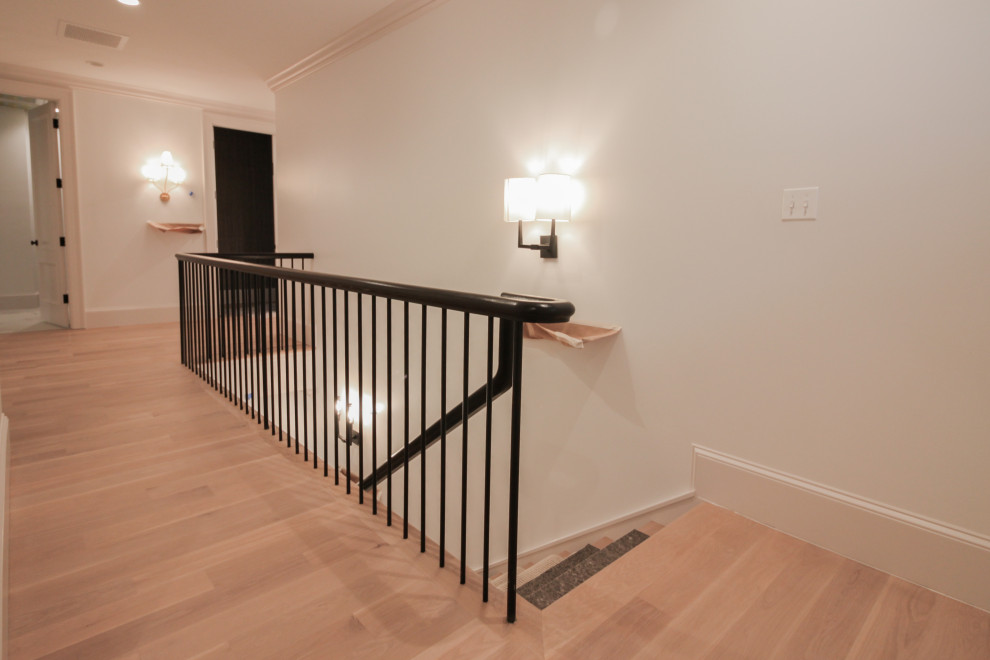 Пример оригинального дизайна: большая п-образная лестница в стиле модернизм с деревянными ступенями, крашенными деревянными подступенками, перилами из смешанных материалов и панелями на стенах