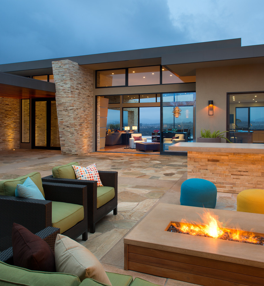 Photo of a large contemporary backyard patio in San Diego with a fire feature, no cover and natural stone pavers.