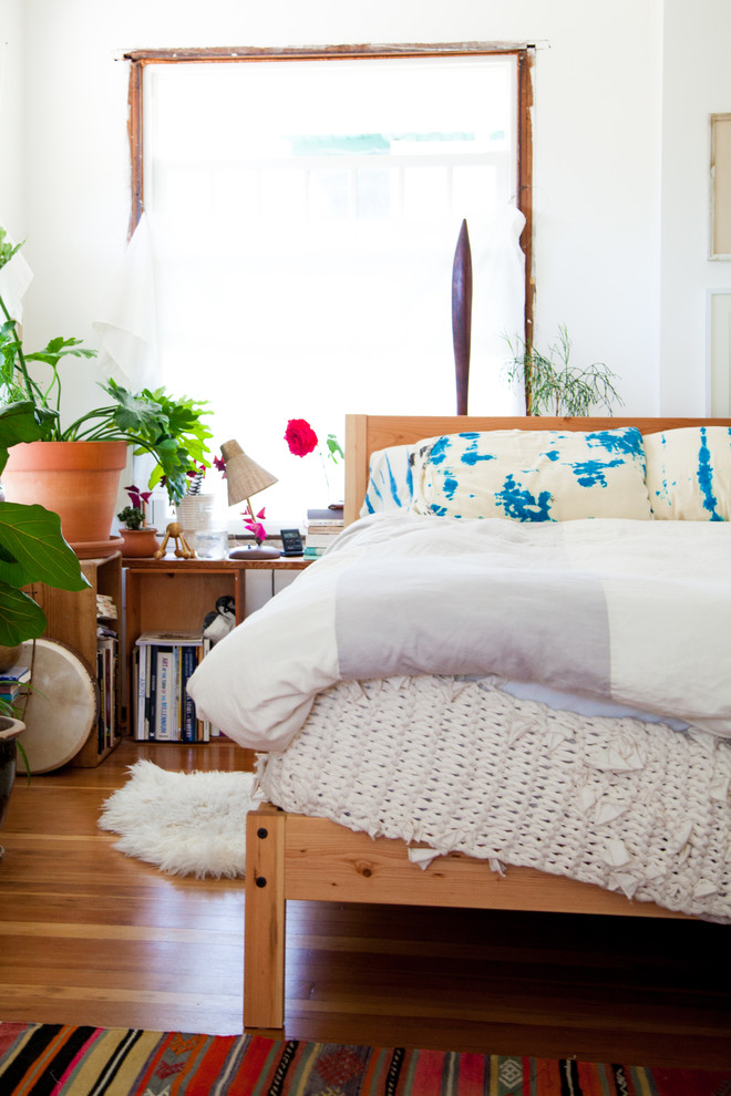 Large eclectic master medium tone wood floor bedroom photo in Seattle with white walls