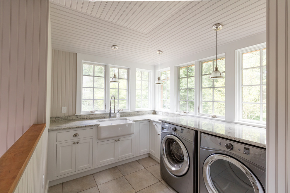 Photo of a mid-sized traditional l-shaped utility room in Philadelphia with a double-bowl sink, recessed-panel cabinets, white cabinets, marble benchtops, grey walls, ceramic floors and a side-by-side washer and dryer.