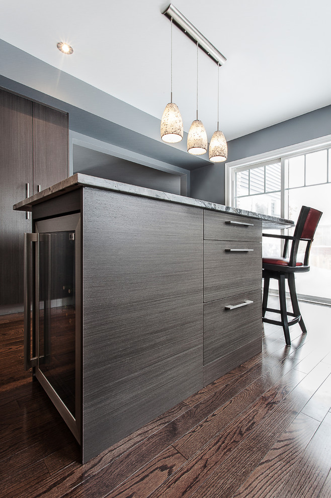 This is an example of a large contemporary u-shaped eat-in kitchen in Ottawa with flat-panel cabinets, a double-bowl sink, grey cabinets, granite benchtops, stainless steel appliances, dark hardwood floors and with island.
