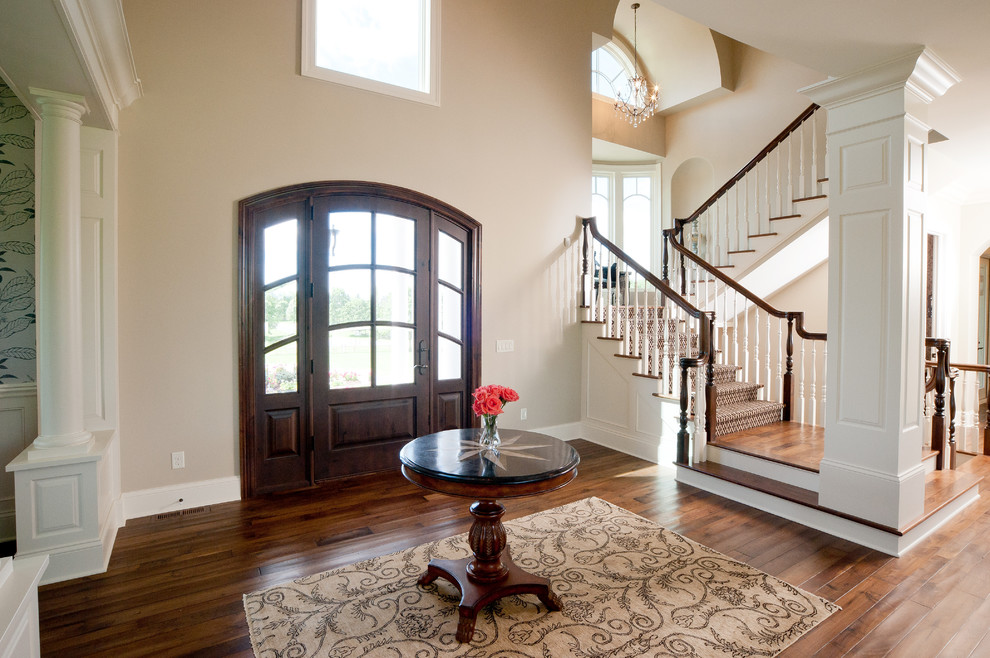 This is an example of a traditional entryway in Minneapolis with a single front door, a dark wood front door and brown floor.
