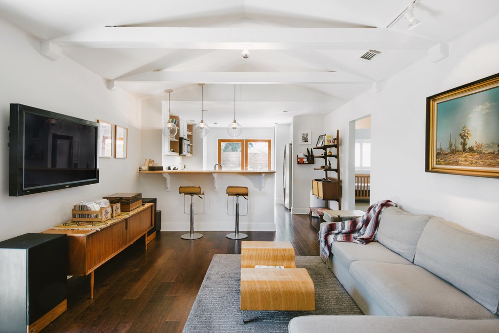 Inspiration for a 1960s open concept dark wood floor living room remodel in Orange County with white walls and a wall-mounted tv