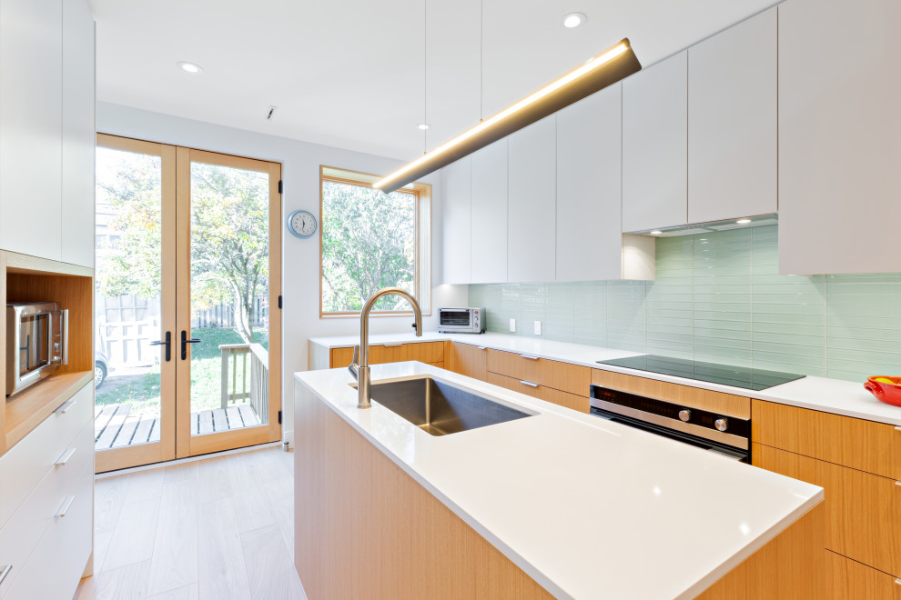 Cette image montre une cuisine design de taille moyenne avec un évier 1 bac, une crédence verte, îlot, un sol jaune et un plan de travail blanc.