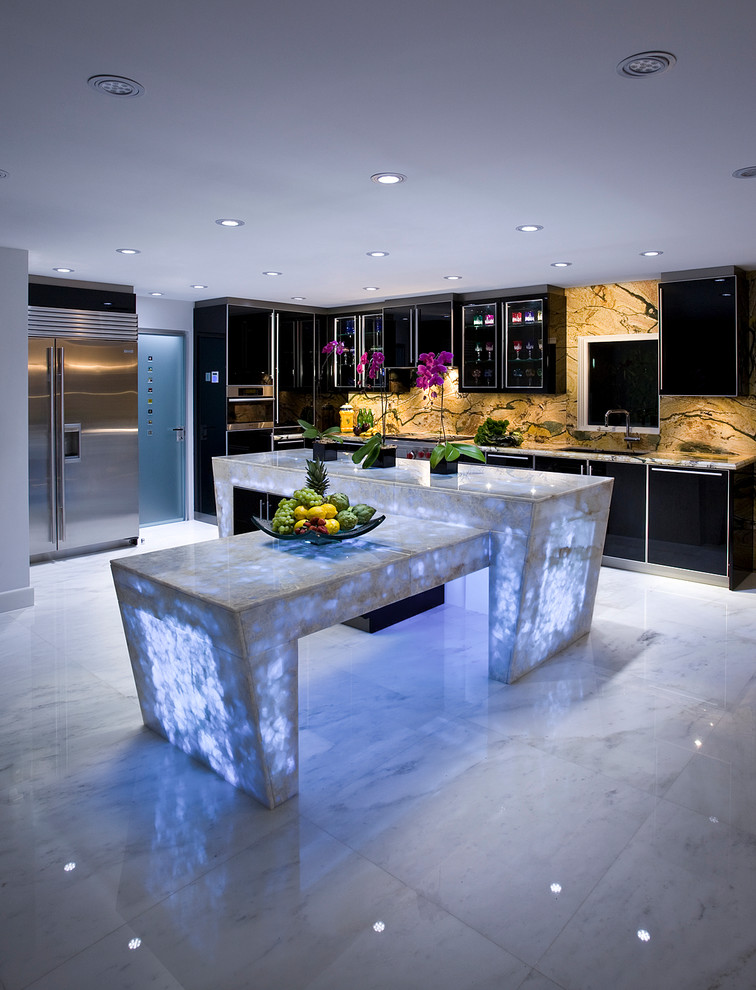 Large contemporary l-shaped kitchen in Miami with a double-bowl sink, glass-front cabinets, black cabinets, quartzite benchtops, multi-coloured splashback, stone slab splashback, stainless steel appliances, marble floors, with island and white floor.