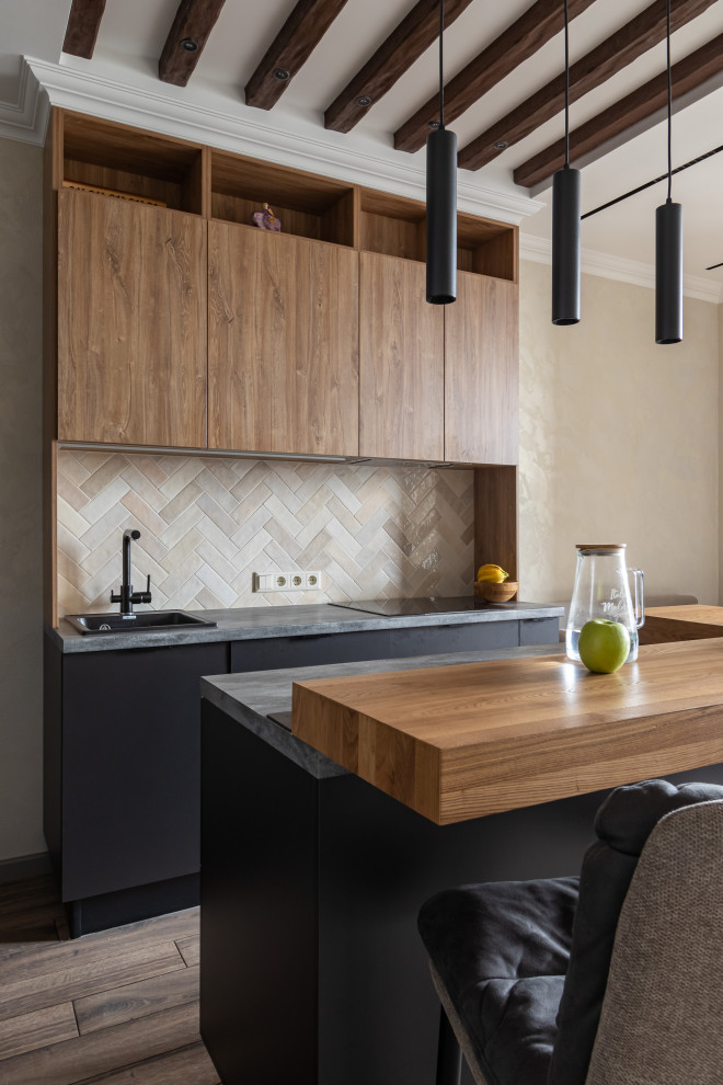Mid-sized contemporary l-shaped eat-in kitchen in Saint Petersburg with a drop-in sink, flat-panel cabinets, medium wood cabinets, beige splashback, ceramic splashback, black appliances, laminate floors, with island, brown floor, grey benchtop and exposed beam.